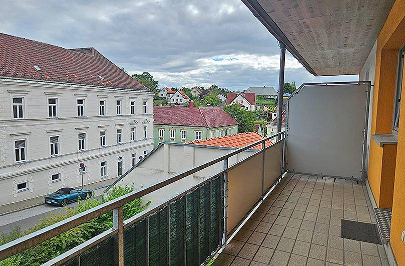 Balkon mit Fliesenboden und weitem Blick über die Stadt und die umliegende Wohnbebauung.