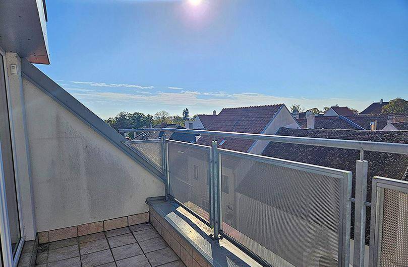 Geräumiger Balkon mit Metallgeländer und weitem Blick über die umliegenden Dächer.