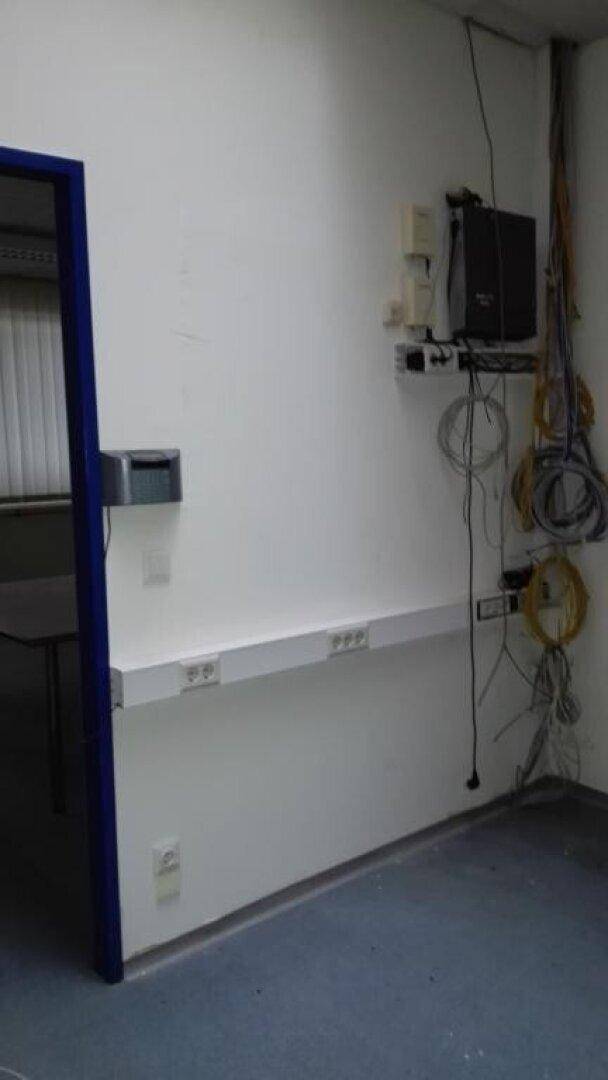 Wandbereich mit zahlreichen Kabeln, Steckdosen und Netzwerkgeräten in einem Technikraum.