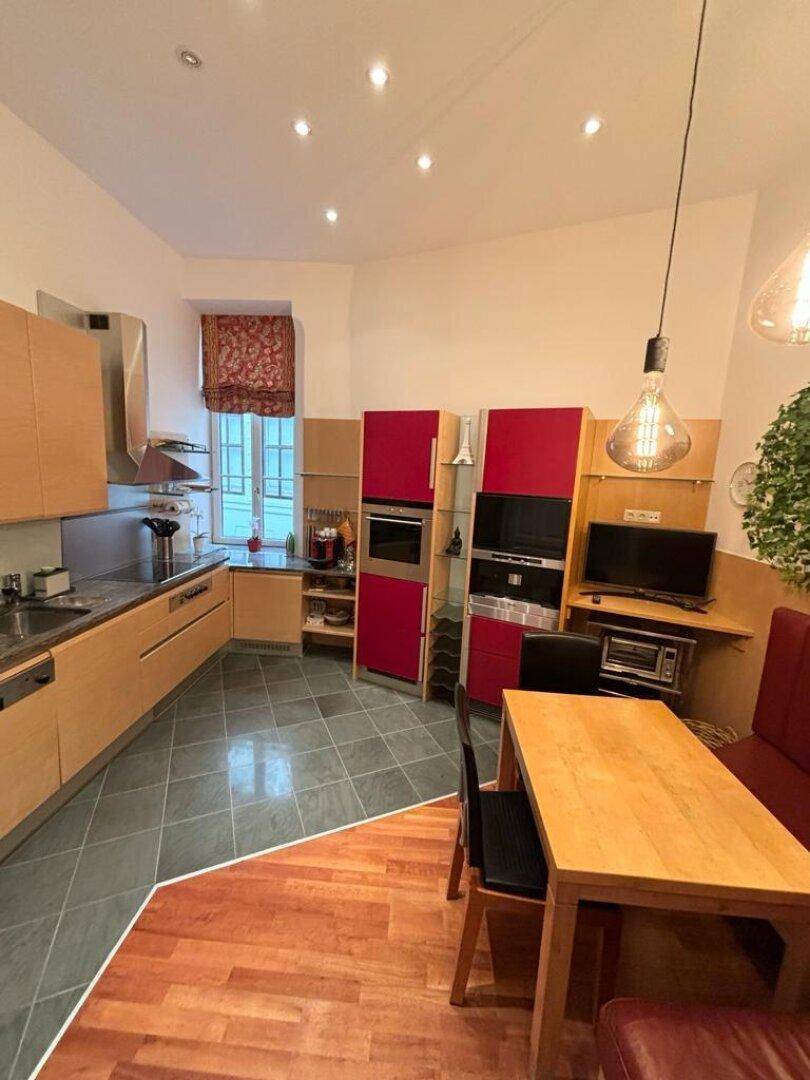 Geräumige Wohnküche mit Essbereich, Holzschränken und modernen Geräten.