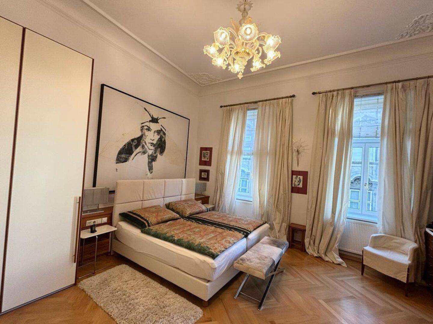 Geräumiges Schlafzimmer mit Doppelbett, Einbauschränken und hohen Decken.