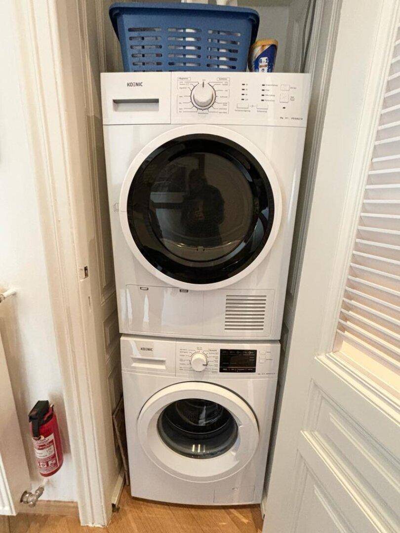 Praktischer Waschbereich mit gestapelter Waschmaschine und Trockner in einem Schrank.