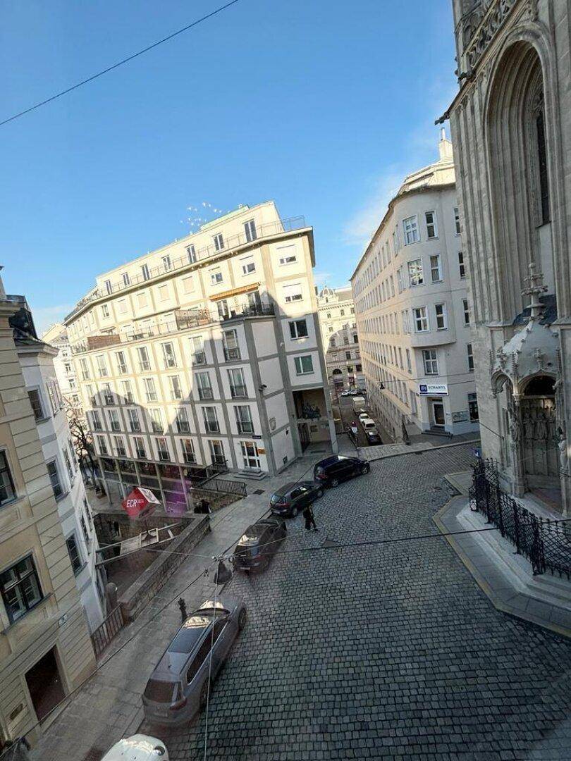 Blick auf eine historische Gasse mit Kopfsteinpflaster und umliegenden Gebäuden.