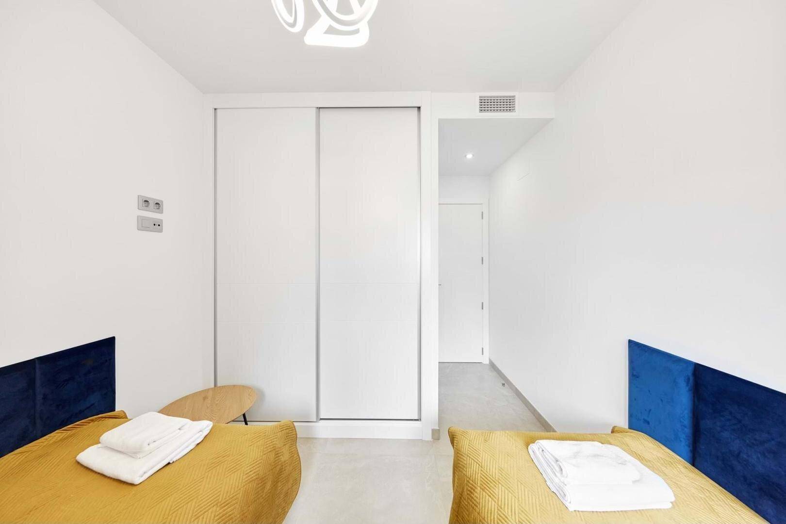 Schlafzimmer mit zwei Einzelbetten und integriertem Kleiderschrank.