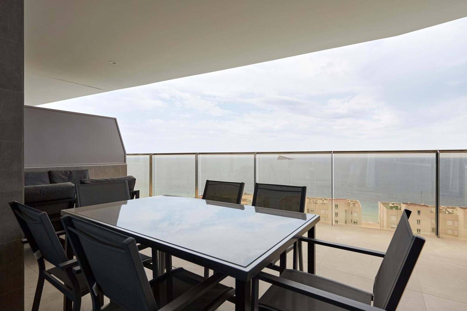 Geräumige Terrasse mit Esstisch und Meerblick, ideal für Mahlzeiten im Freien.