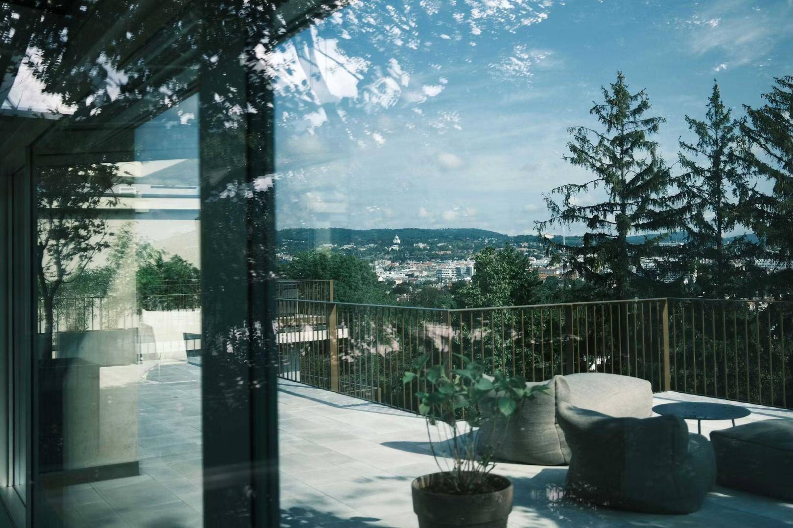Terrasse mit Panoramablick über die Stadt und die umliegende grüne Hügellandschaft.