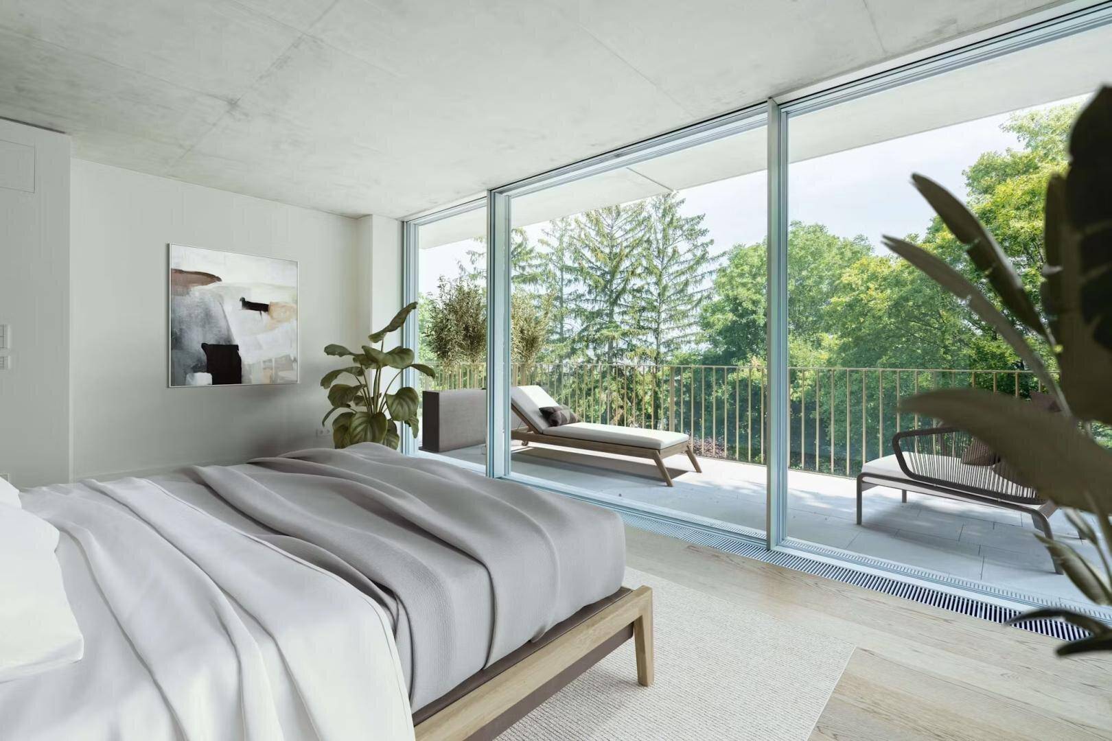Schlafzimmer mit Holzboden, Blick ins Grüne und Zugang zu einem möblierten Außenbereich.