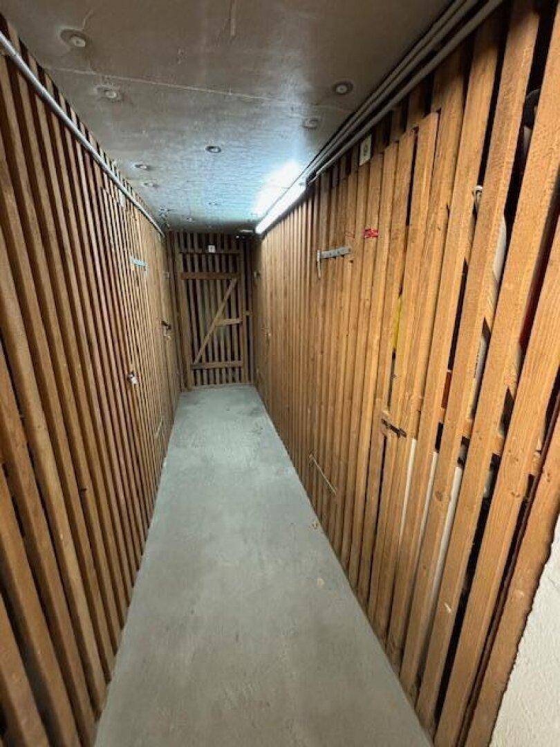 Kellerabteil mit Holzverschlägen für zusätzlichen Stauraum.