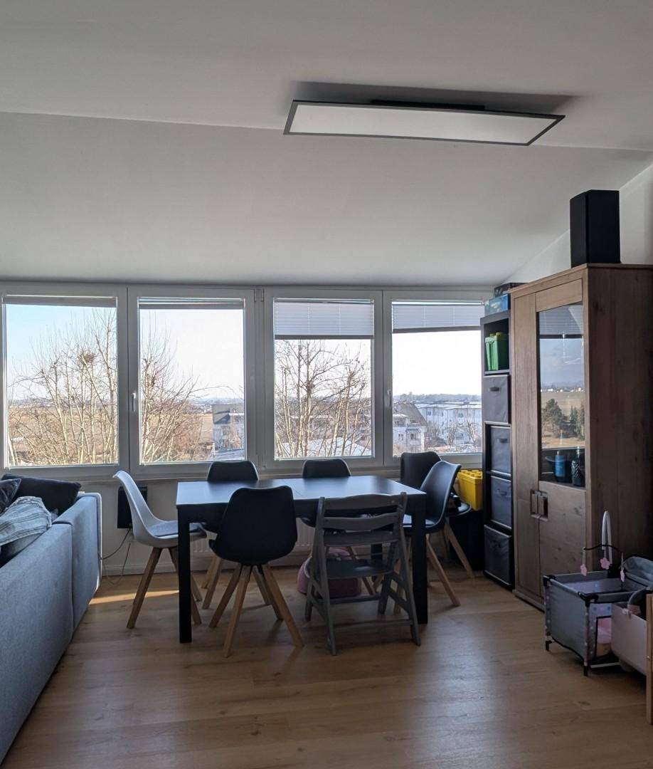 Lichtdurchfluteter Essbereich mit modernem Esstisch, Stühlen und Panoramablick ins Freie.