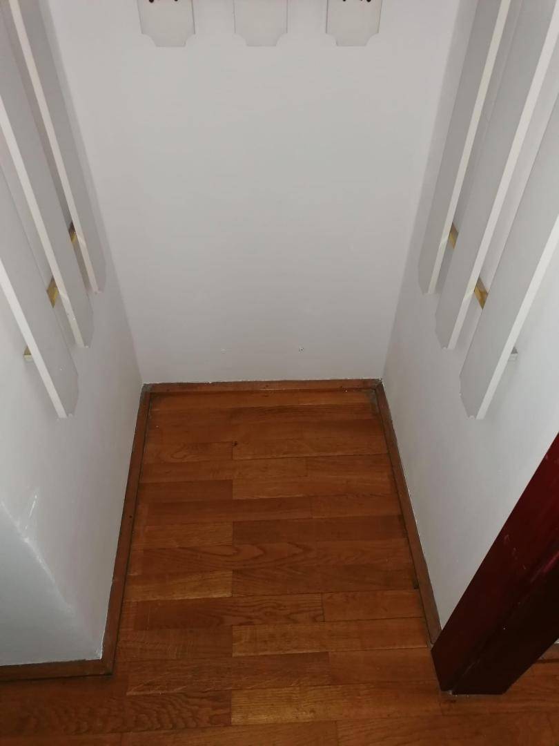 Kleiner Abstellraum mit Holzboden und weißen Wänden, ideal für zusätzlichen Stauraum.