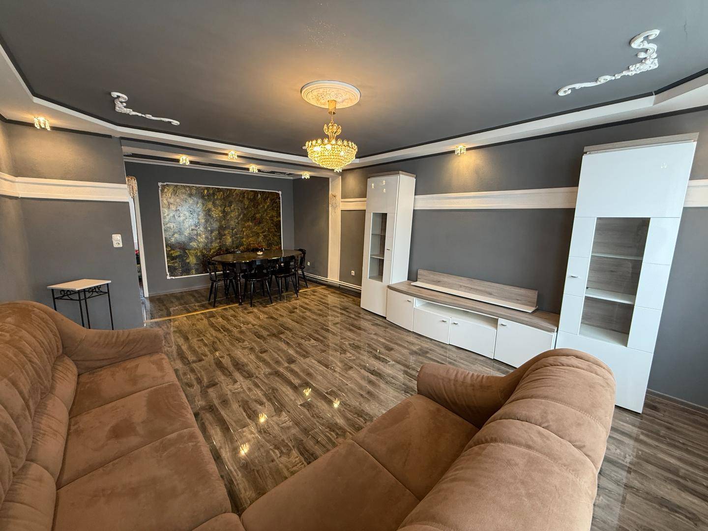 Geräumiger Wohn-Essbereich mit großem Sofa, Esstisch und modernen Schränken.