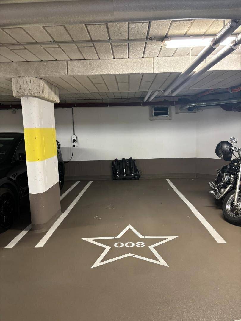 Einzelner Parkplatz in einer Tiefgarage, gekennzeichnet mit einer Sternmarkierung und Nummer.
