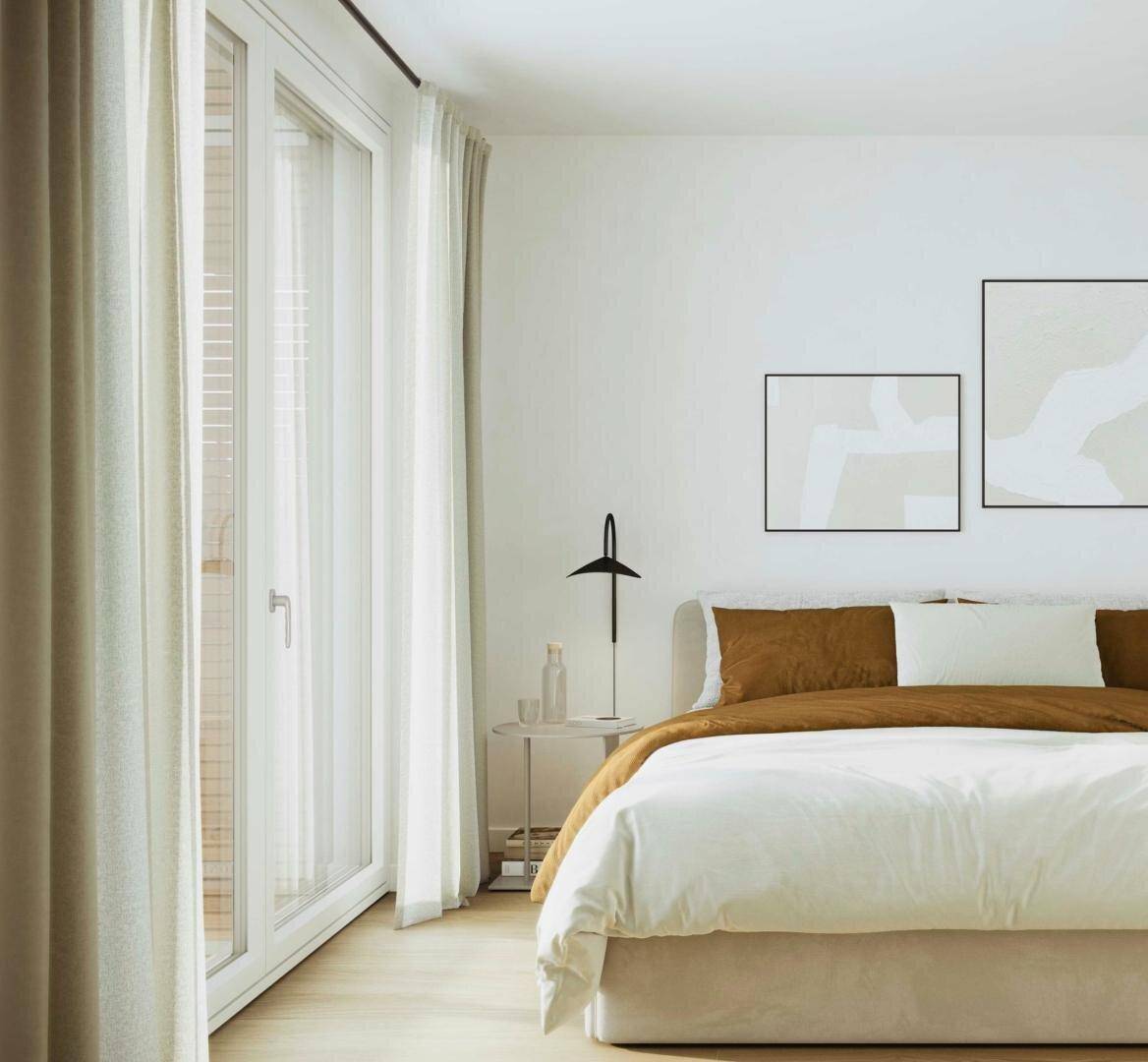 Helles Schlafzimmer mit Doppelbett, Holzboden und Zugang zu einem Balkon oder einer Terrasse.