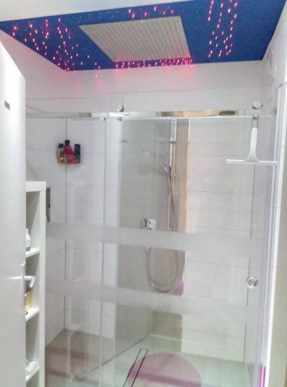 Modernes Badezimmer mit großer Duschkabine und einer Decke mit Sternenhimmel-Beleuchtung.