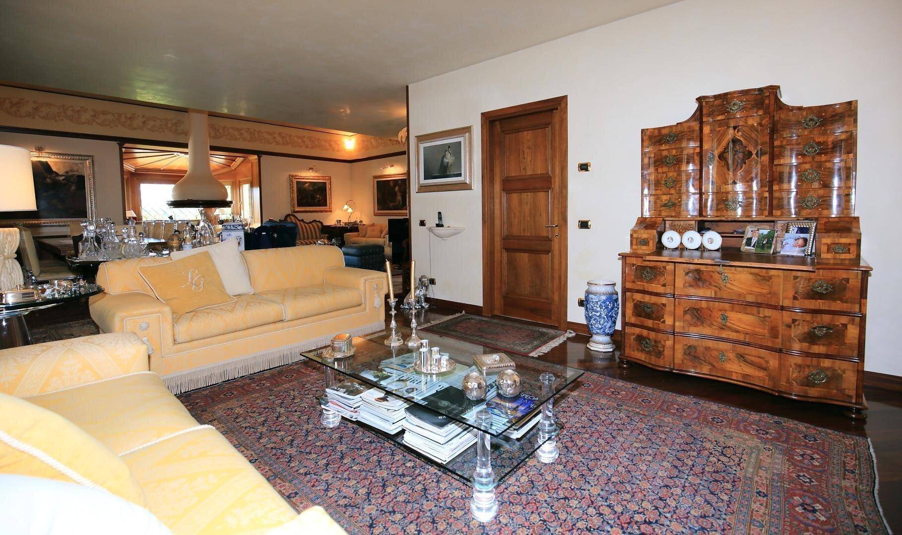 Geräumiges Wohnzimmer mit klassischer Einrichtung, Teppich und einem eleganten Sideboard.