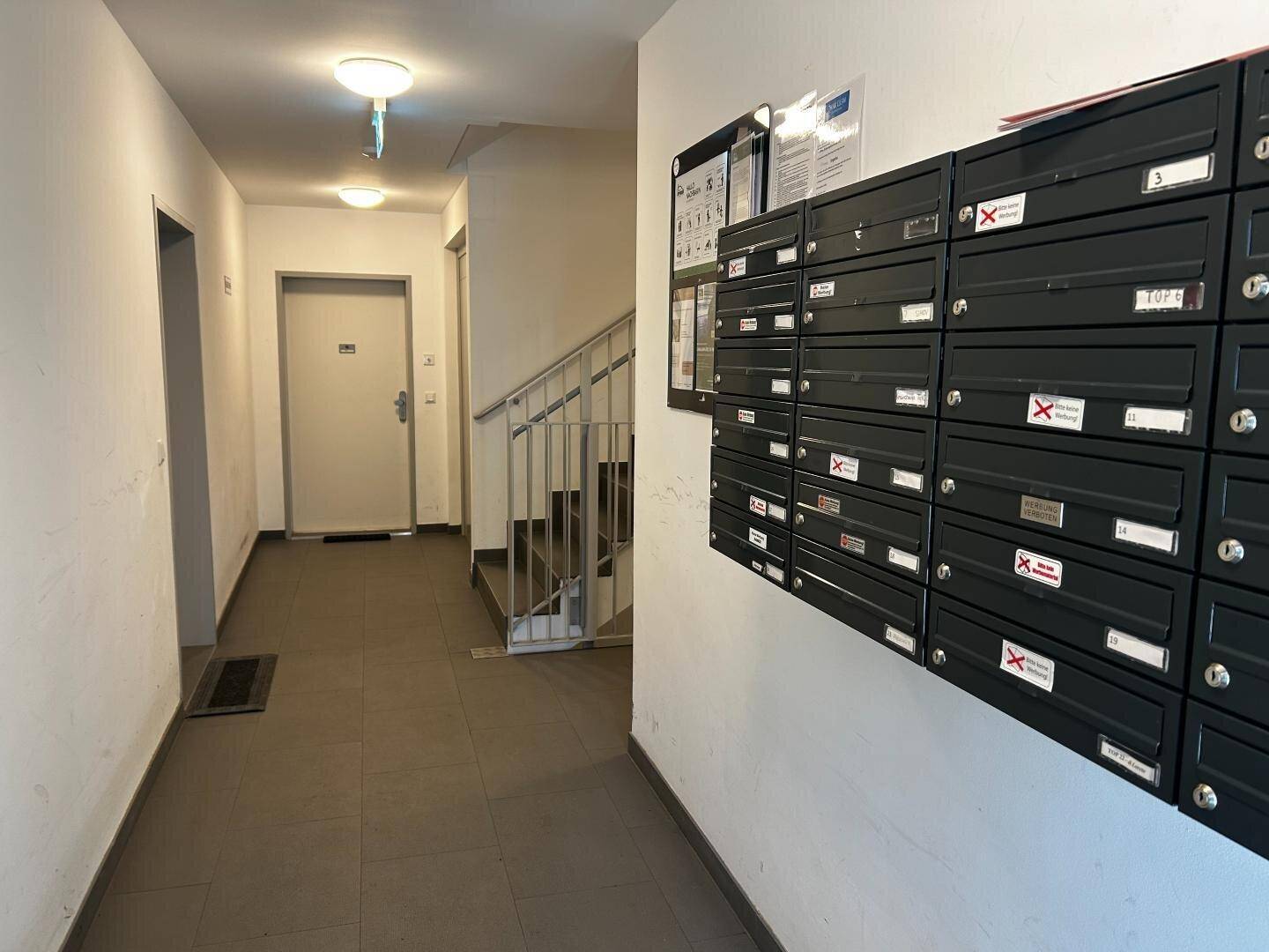 Gemeinschaftlicher Flur mit Briefkästen und Treppenhauszugang im Gebäude.