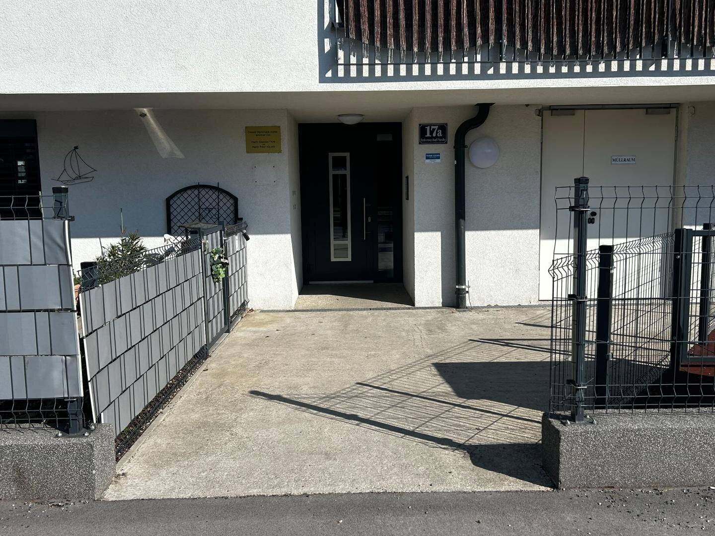 Eingangsbereich eines modernen Wohngebäudes mit Zugang zur Straße.