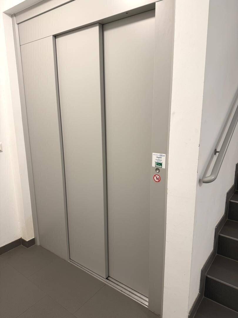 Moderner Aufzug im Treppenhaus eines Wohngebäudes.