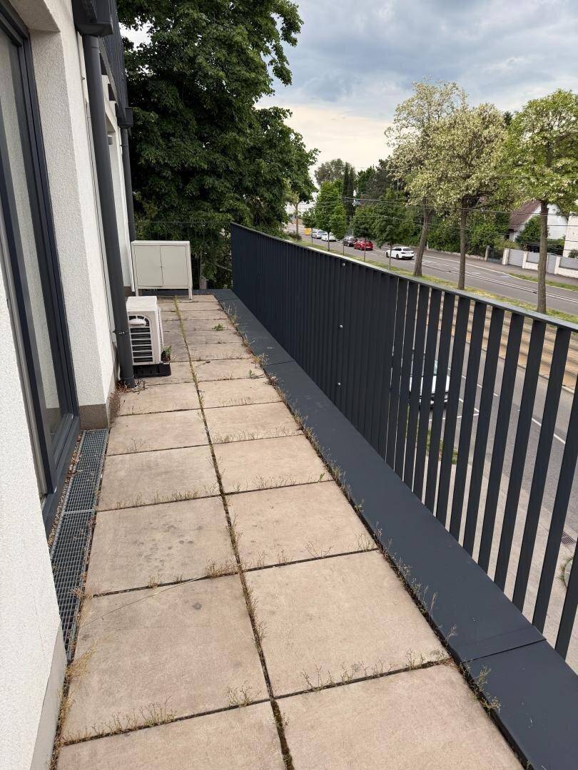 Geräumiger Balkon mit Fliesen und Blick auf die belebte Straße.