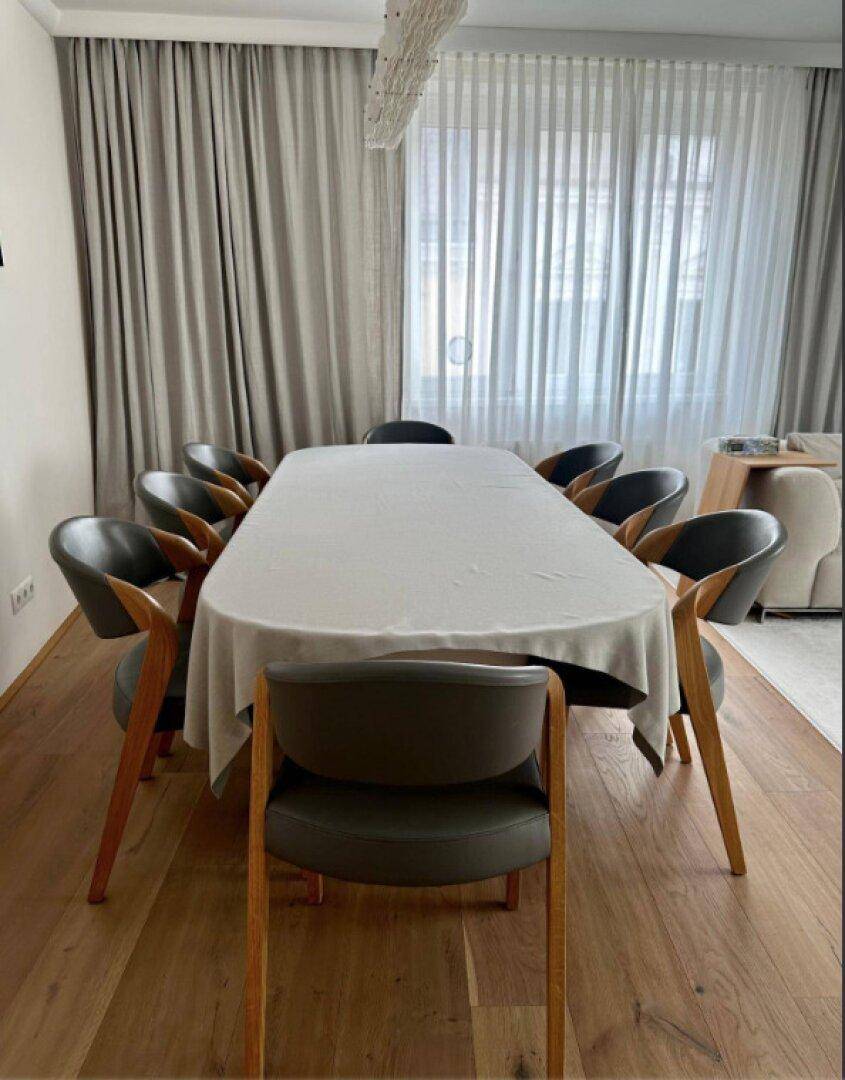 Eleganter Essbereich mit großem Tisch, modernen Stühlen und Holzboden.