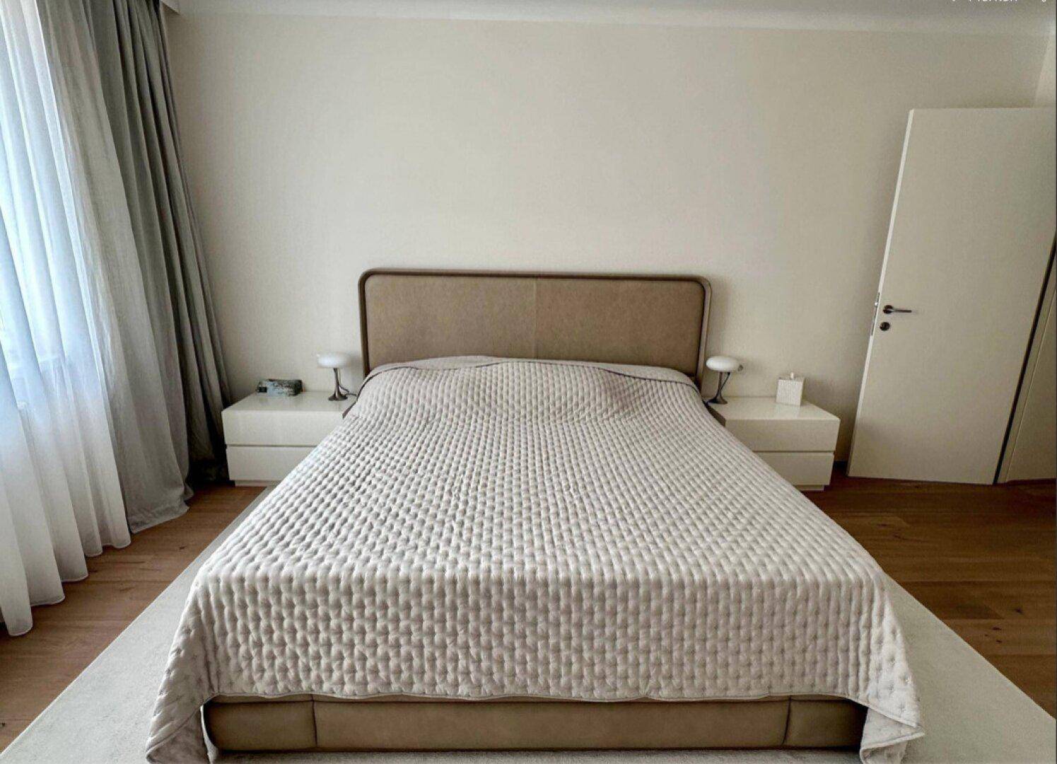 Modernes Schlafzimmer mit großem Doppelbett, Nachttischen und hellem Ambiente.