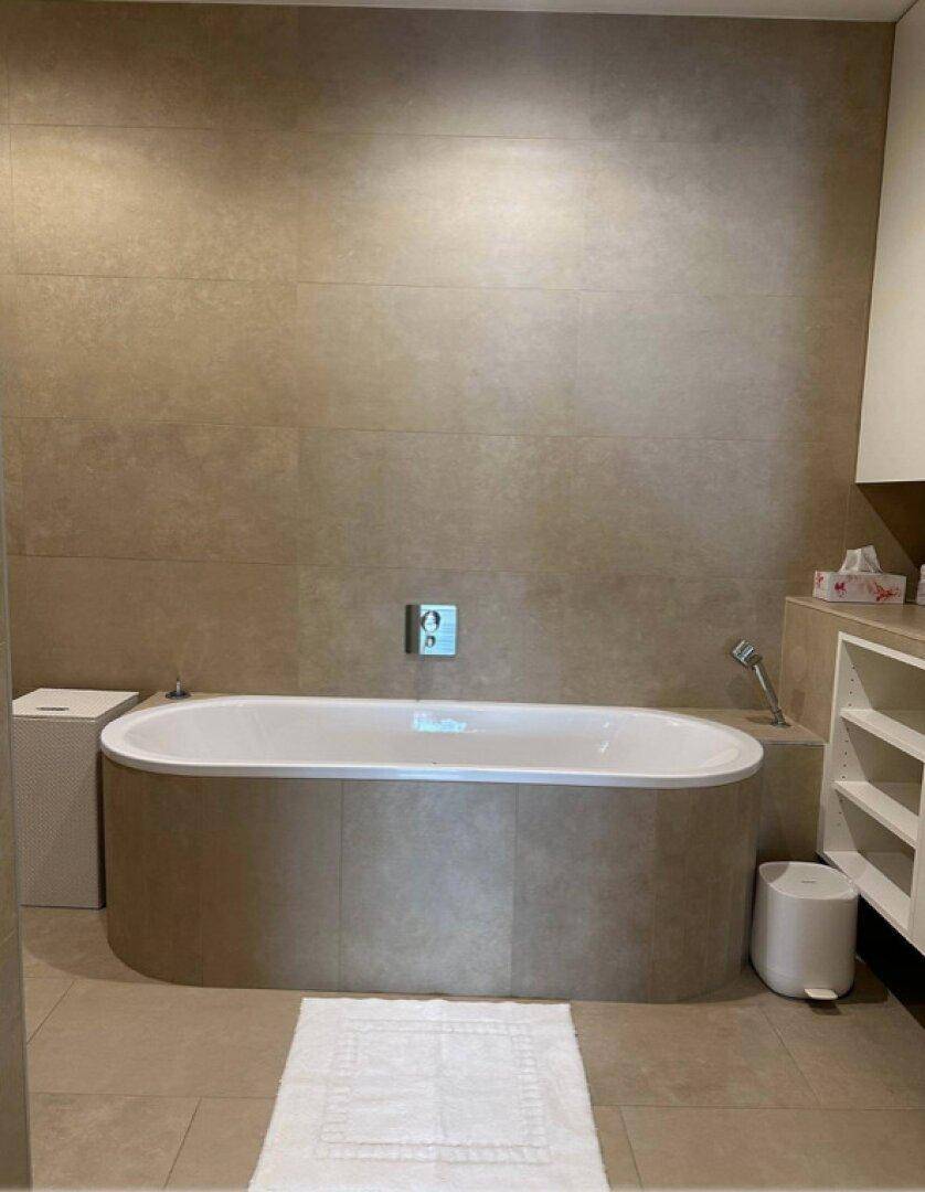 Modernes Badezimmer mit freistehender Badewanne und großformatigen Fliesen.
