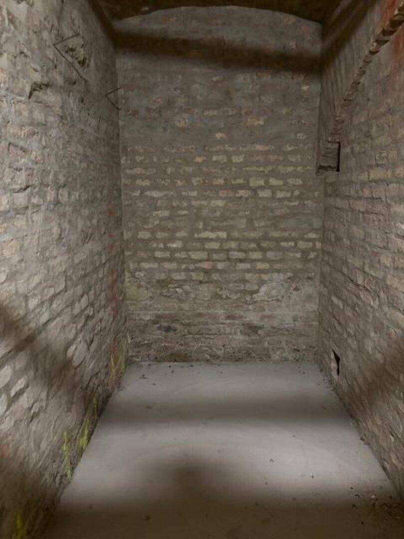 Unausgebauter Kellerraum mit sichtbaren Ziegelwänden und einfachem Betonboden.