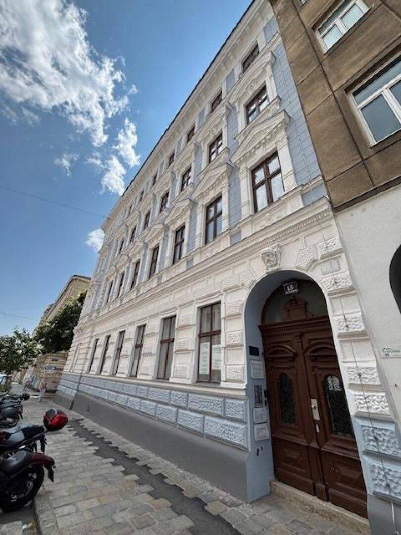 Historisches Gebäude mit blauer Fassade, verzierten Fenstern und klassischer Architektur.