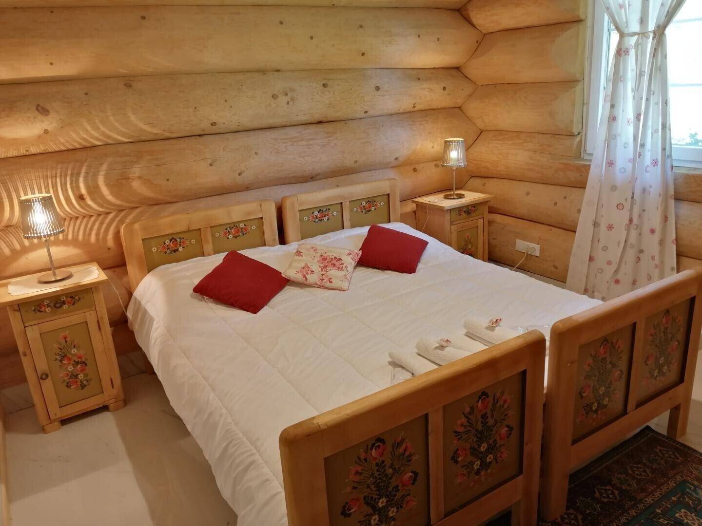 Helles Schlafzimmer mit zwei Einzelbetten und handbemalten Holzmöbeln im traditionellen Stil.