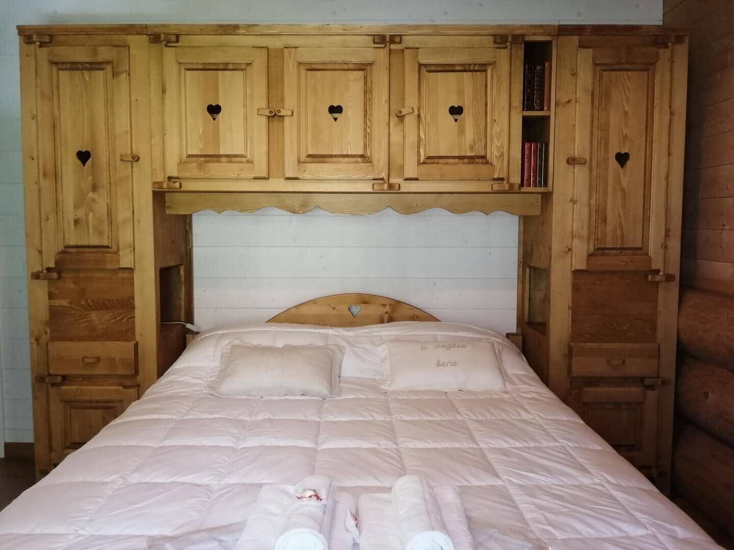 Gemütliches Schlafzimmer mit traditionellen Holzmöbeln und integrierten Schränken im Landhausstil.