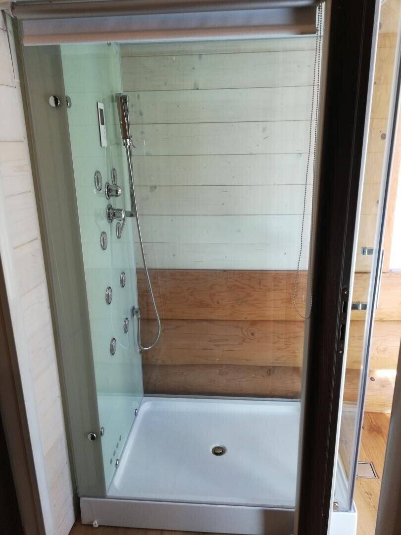 Moderne Duschkabine mit Glaswänden und integrierten Massagedüsen im Badezimmer.