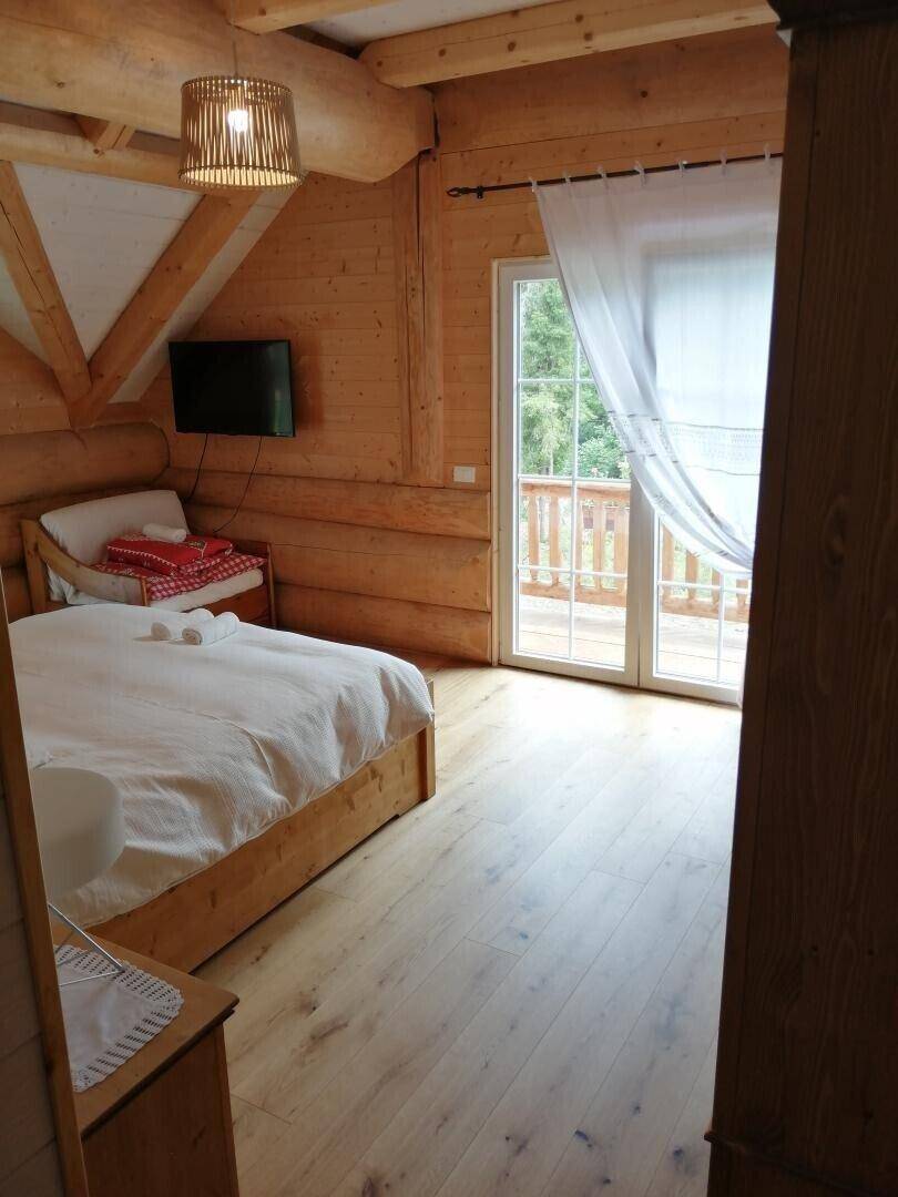 Schlafzimmer mit Holzböden und Balkonzugang, bietet einen schönen Blick ins Grüne.