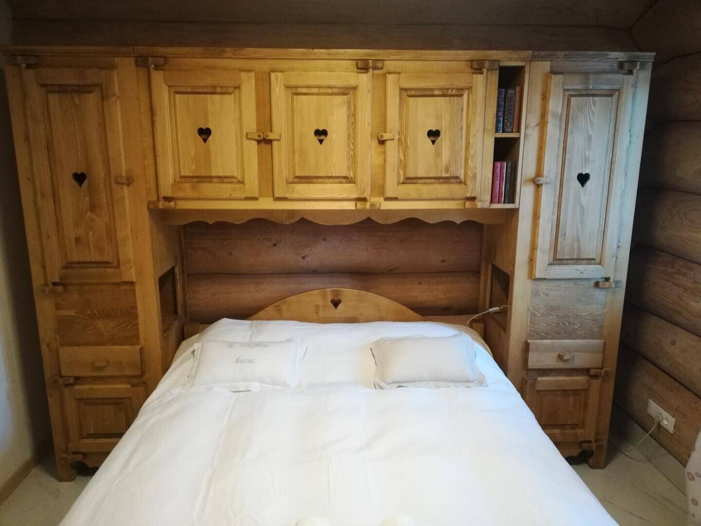 Gemütliches Schlafzimmer mit traditionellen Holzmöbeln und integrierten Schränken im Landhausstil.