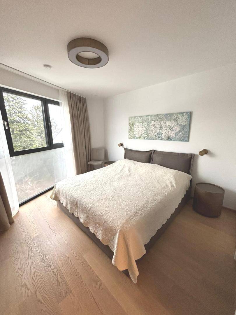 Geräumiges Schlafzimmer mit Doppelbett, Nachttischen und großem Fenster für viel Tageslicht.