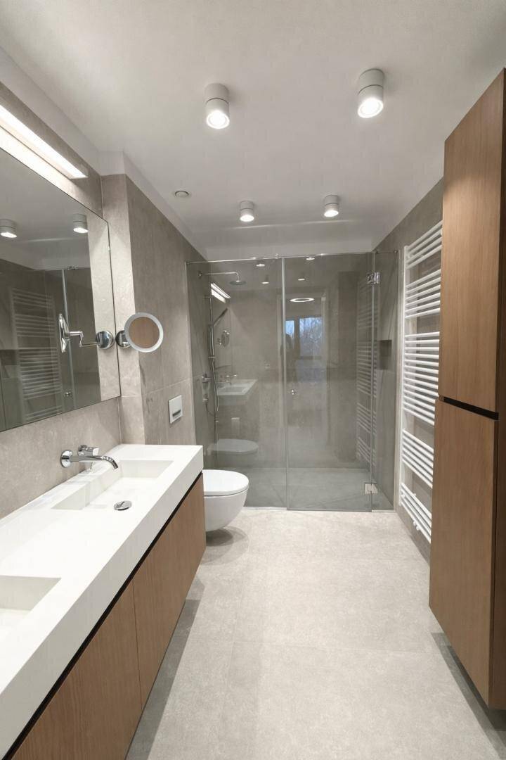 Modernes Badezimmer mit Doppelwaschbecken, großer Spiegelfläche und begehbarer Dusche.