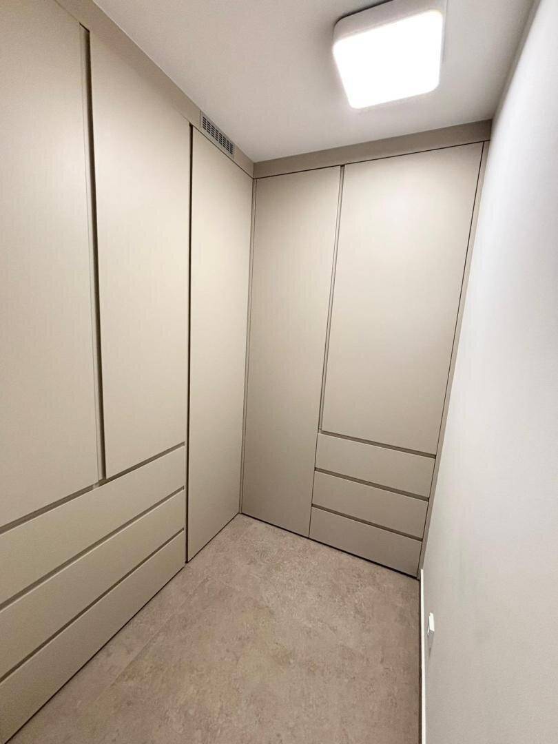 Praktischer begehbarer Kleiderschrank mit maßgefertigten Einbauschränken und viel Stauraum.