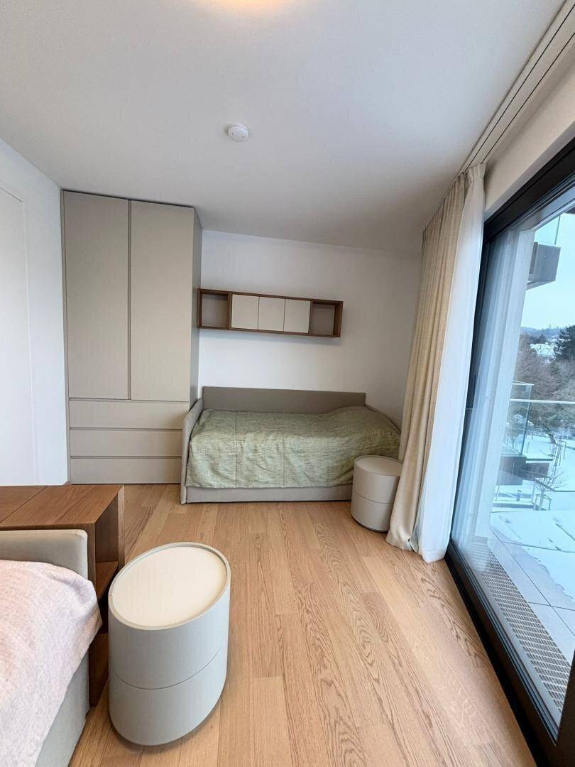 Schlafzimmer mit Einzelbett, Einbauschrank und großem Fenster mit Blick auf die Umgebung.