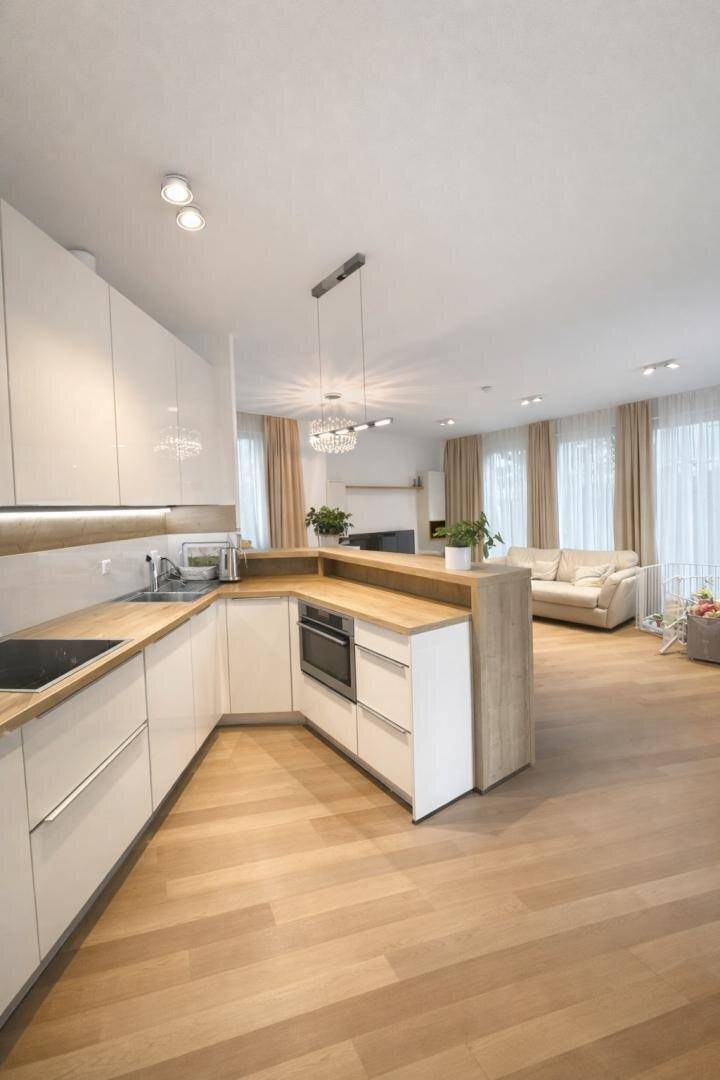 Offener Wohnbereich mit moderner Küche, Essbereich und gemütlichem Sofa.