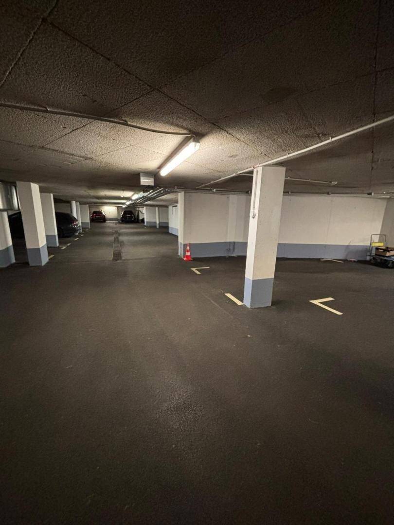 Geräumige Tiefgarage mit markierten Stellplätzen und Beleuchtung.