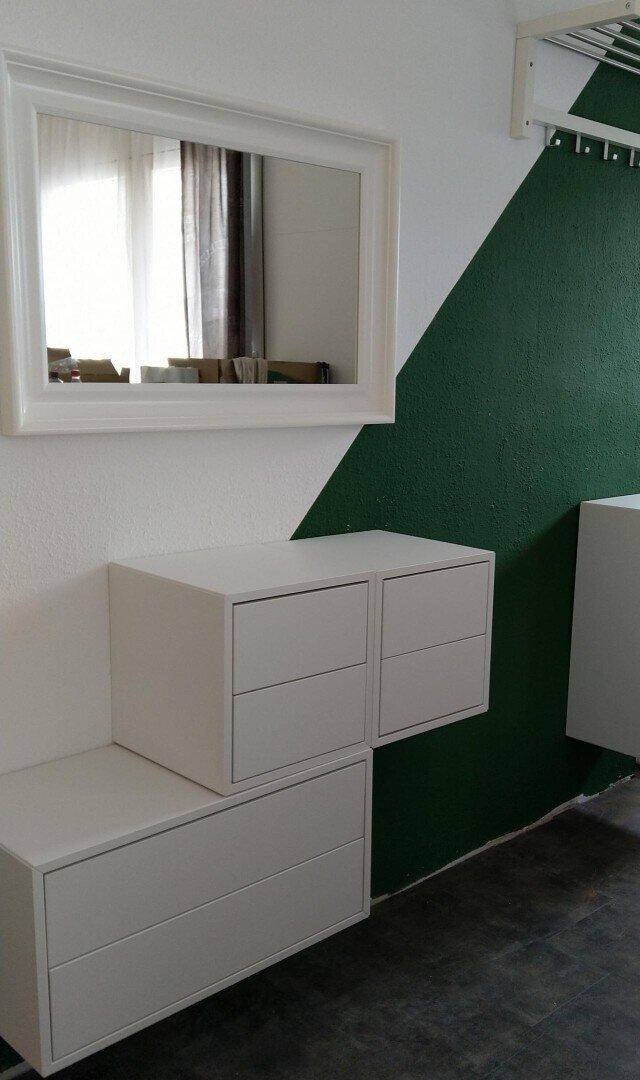 Wandgestaltung mit schwebenden Schubladen und Spiegel in einem modernen Raum.