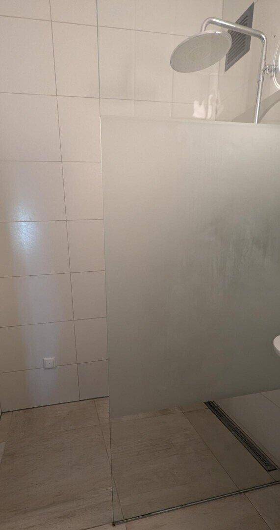 Detaillierte Ansicht der begehbaren Dusche im modernen Badezimmer.