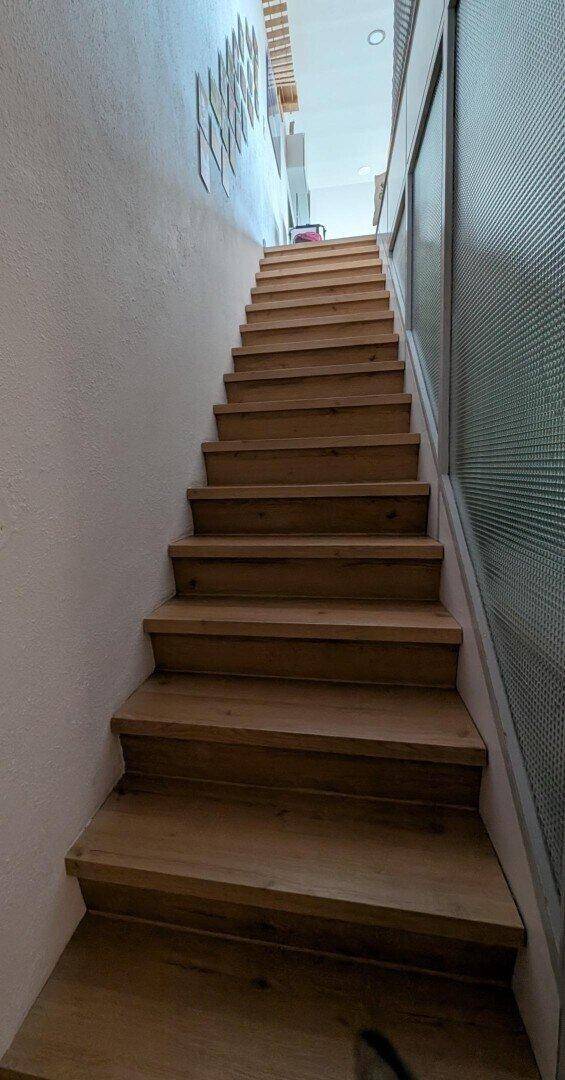 Holztreppe mit modernem Design, die die verschiedenen Ebenen verbindet.