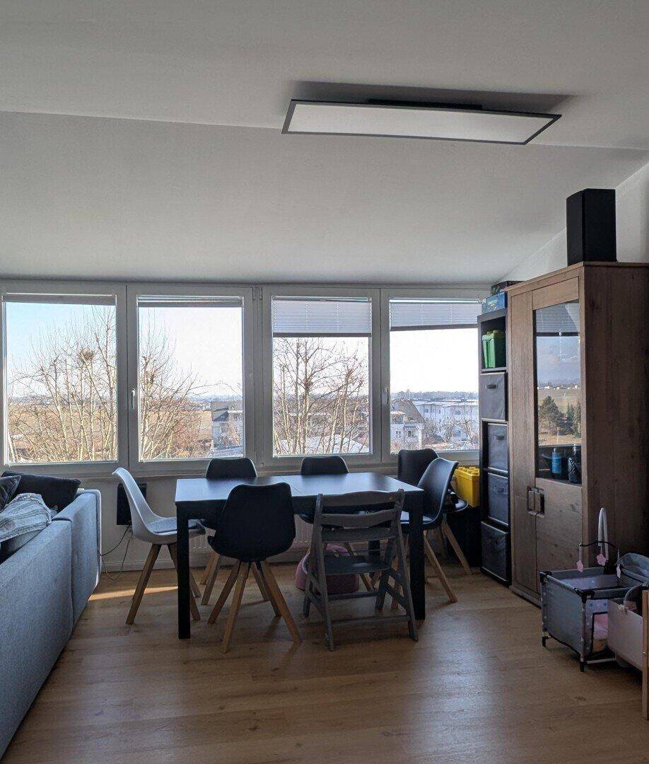 Heller Wohn- und Essbereich mit Holzboden, Esstisch und weitem Ausblick.