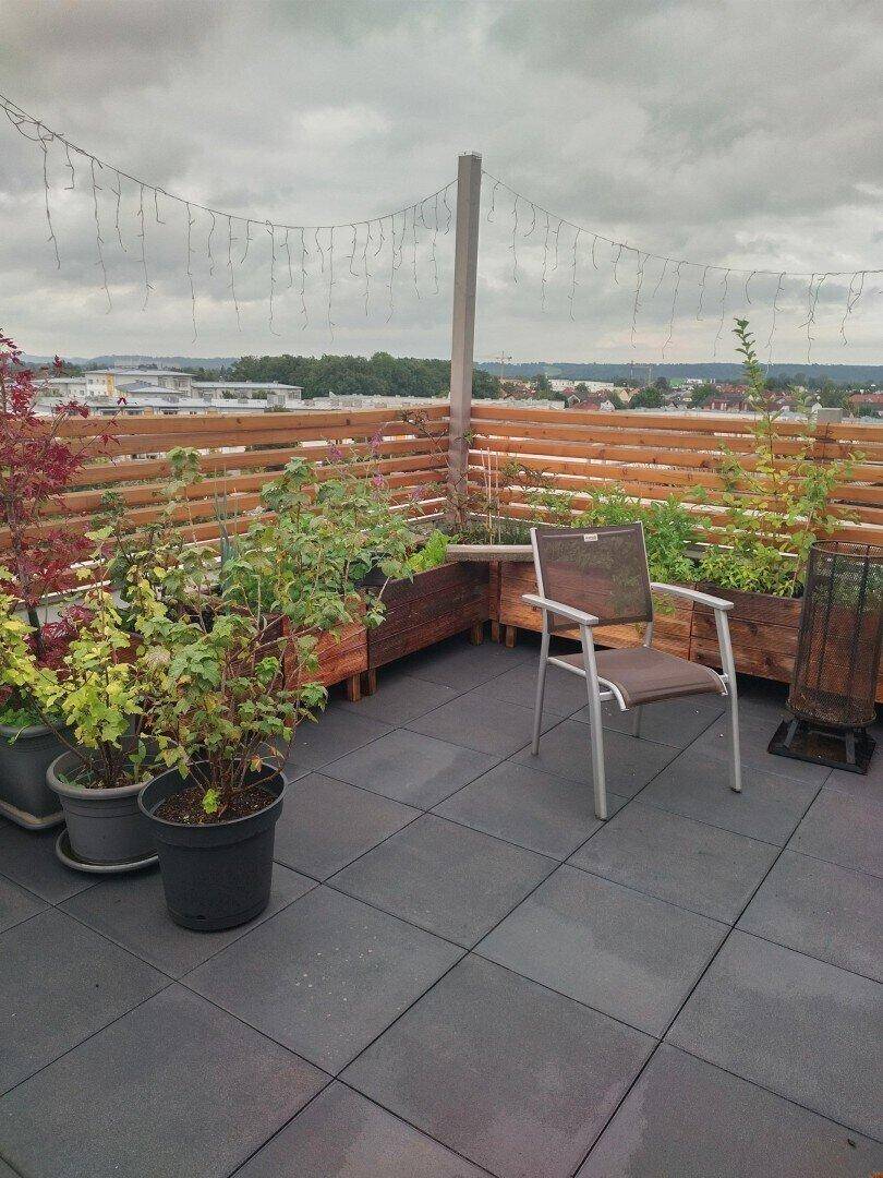 Weitläufige Dachterrasse mit Hochbeeten, Sitzgelegenheit und Panoramablick.