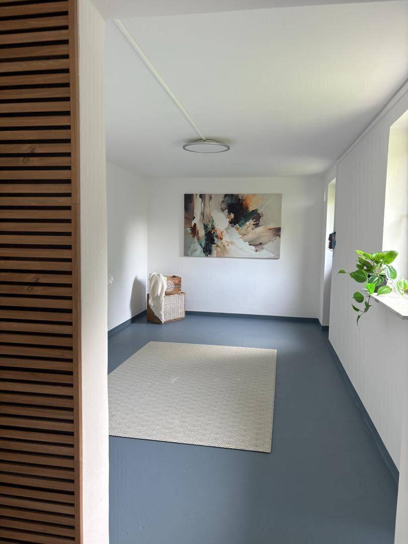 Heller Flur mit Teppich, abstrakter Kunst und schlichter Wandgestaltung.