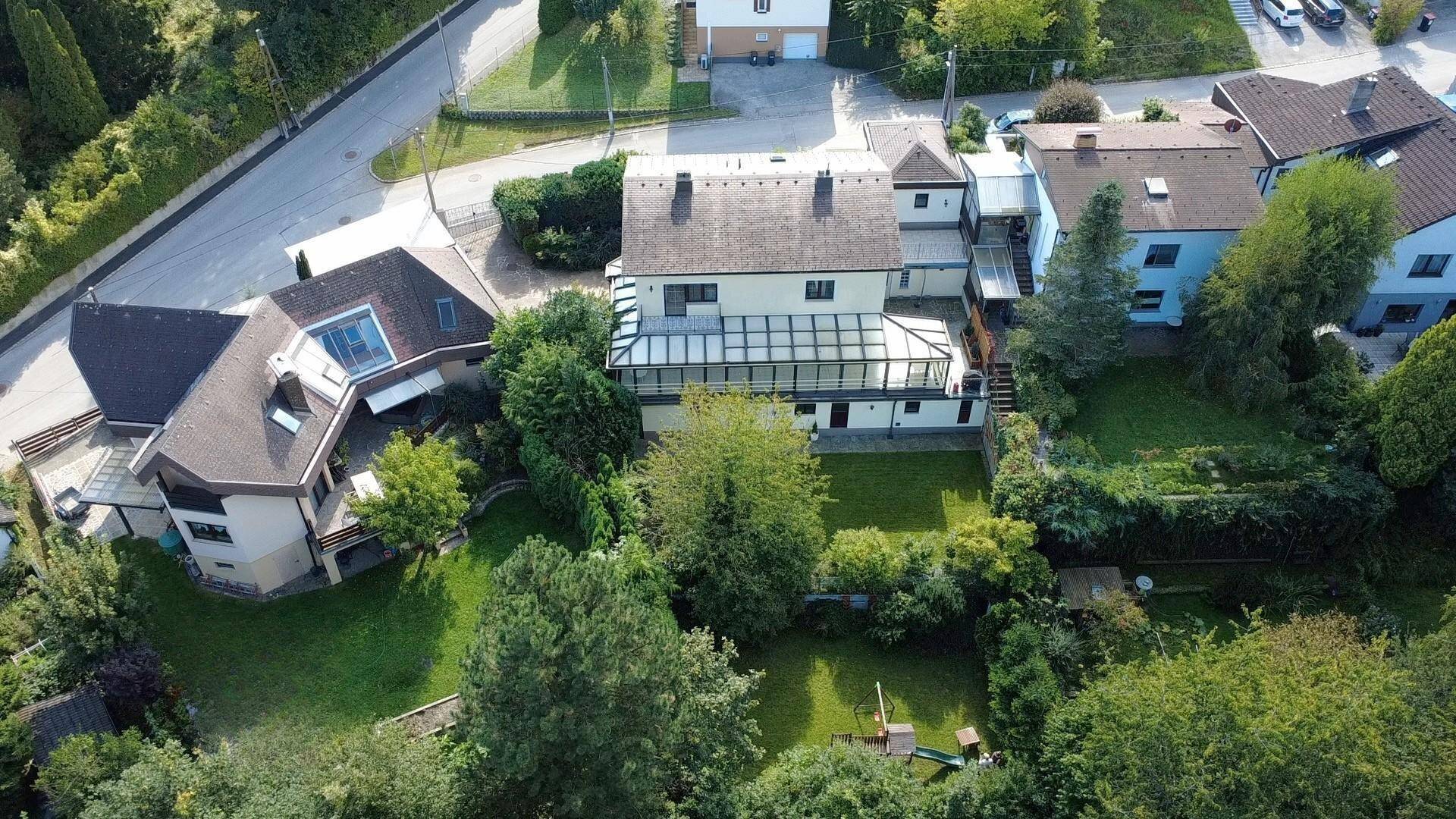 Luftaufnahme des Anwesens mit umliegenden Häusern und weitläufigen Grünflächen.