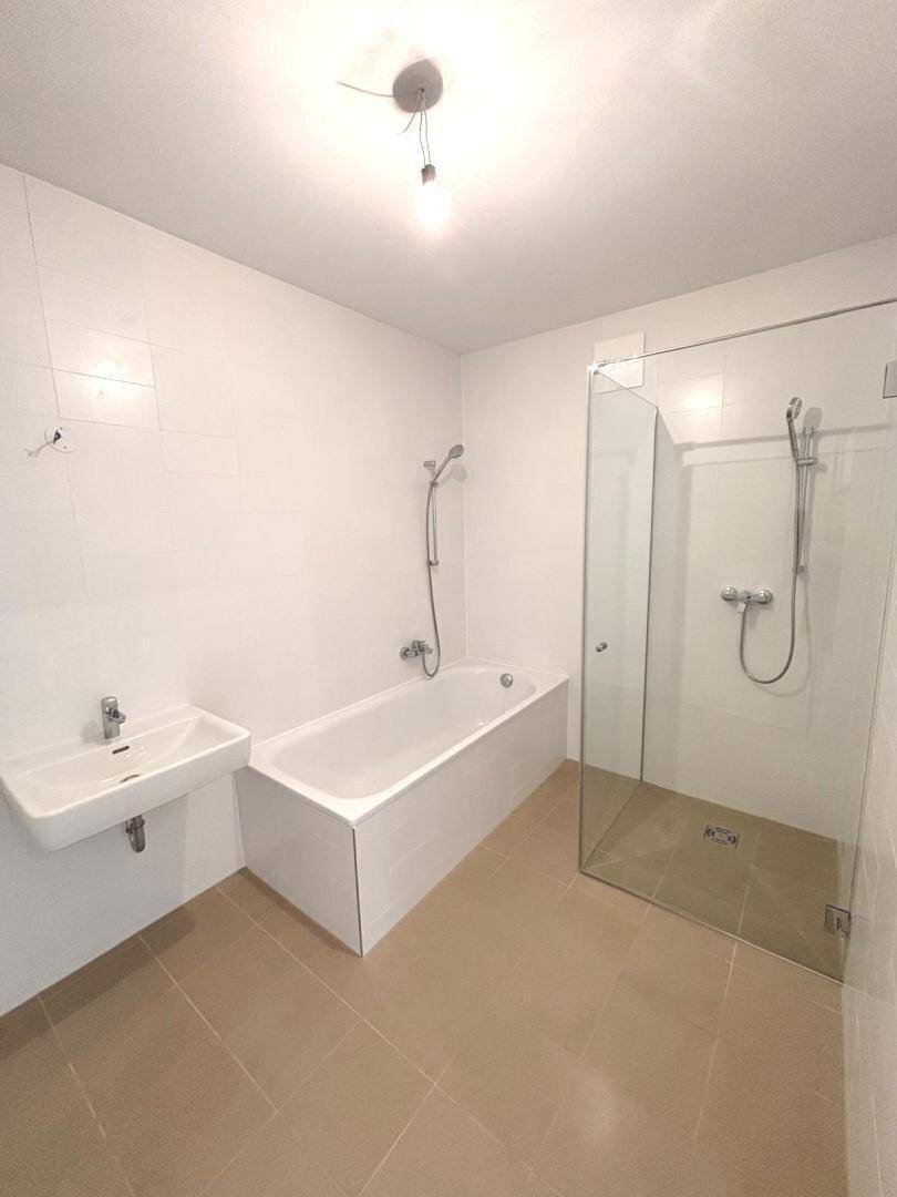Modernes Badezimmer mit Badewanne, ebenerdiger Dusche und einem einzelnen Waschbecken.