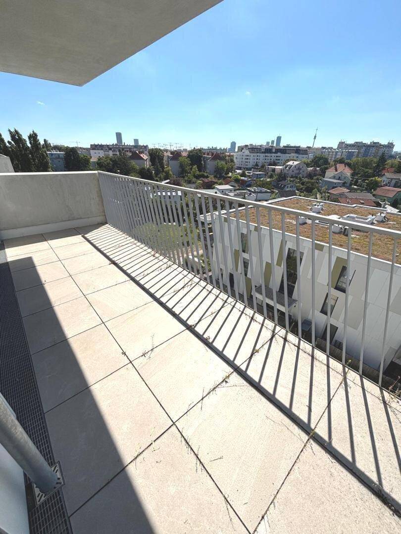 Heller Balkon mit Fliesen und modernem Geländer, ideal für entspannte Stunden im Freien.