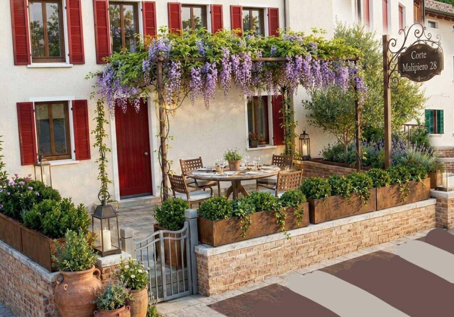 Charmante Terrasse mit Esstisch unter einer Pergola, umgeben von Blumenkästen und Ziegelmauern.