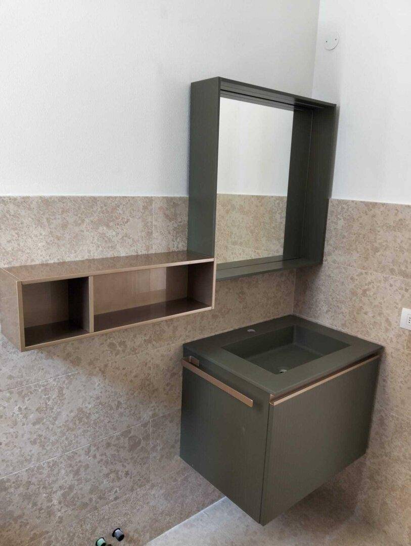 Modernes Badezimmer mit schwebendem Waschtisch, Spiegel und beigefarbenen Fliesen.